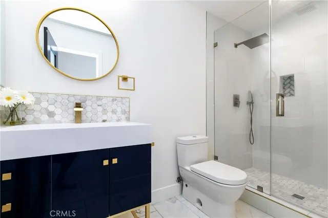 a bathroom with a granite countertop toilet a sink and shower