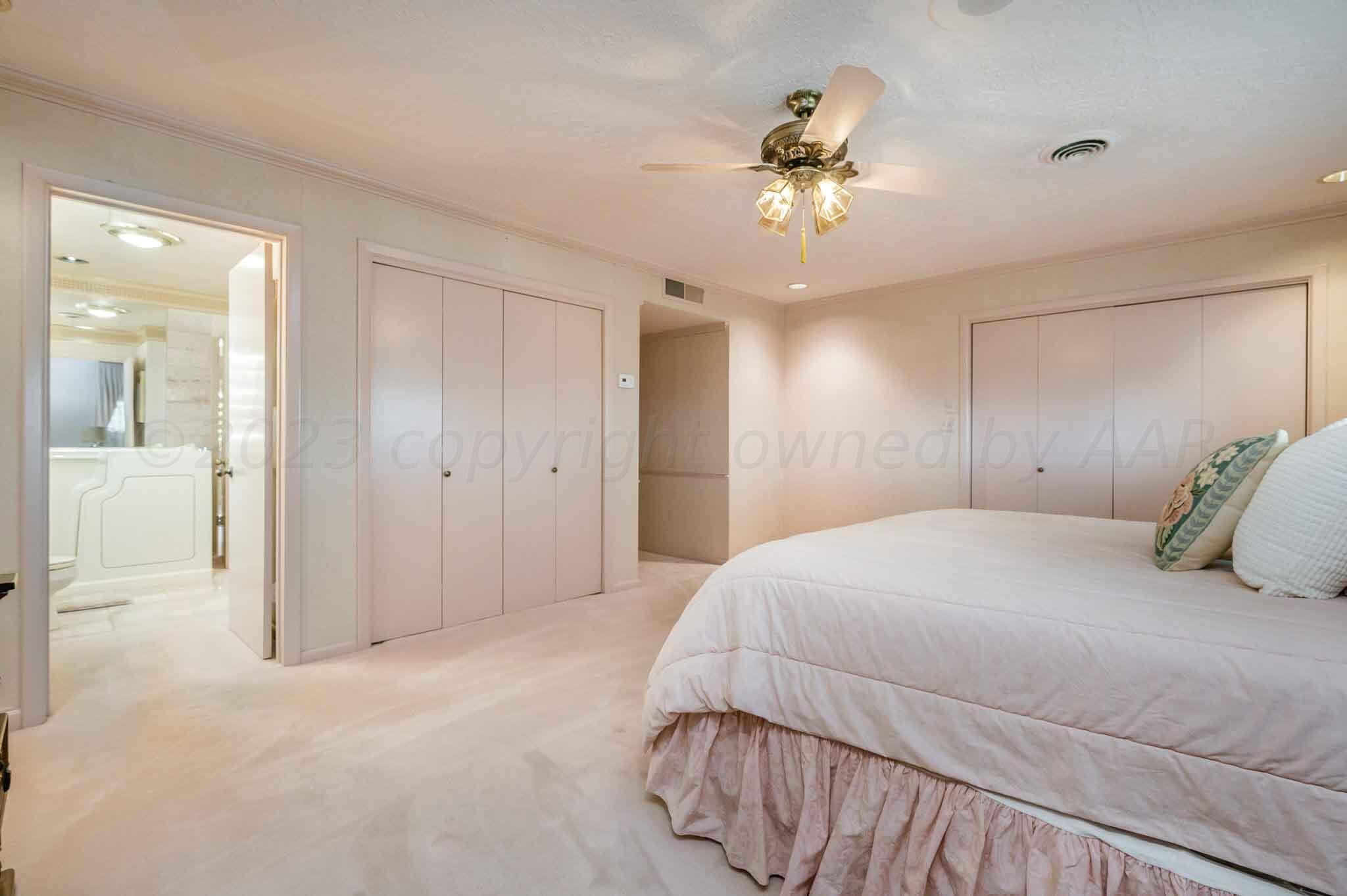 7517 Duling Lane Amarillo, TX 79110 - Photo 23 of 80 a bedroom with a large bed and chandelier