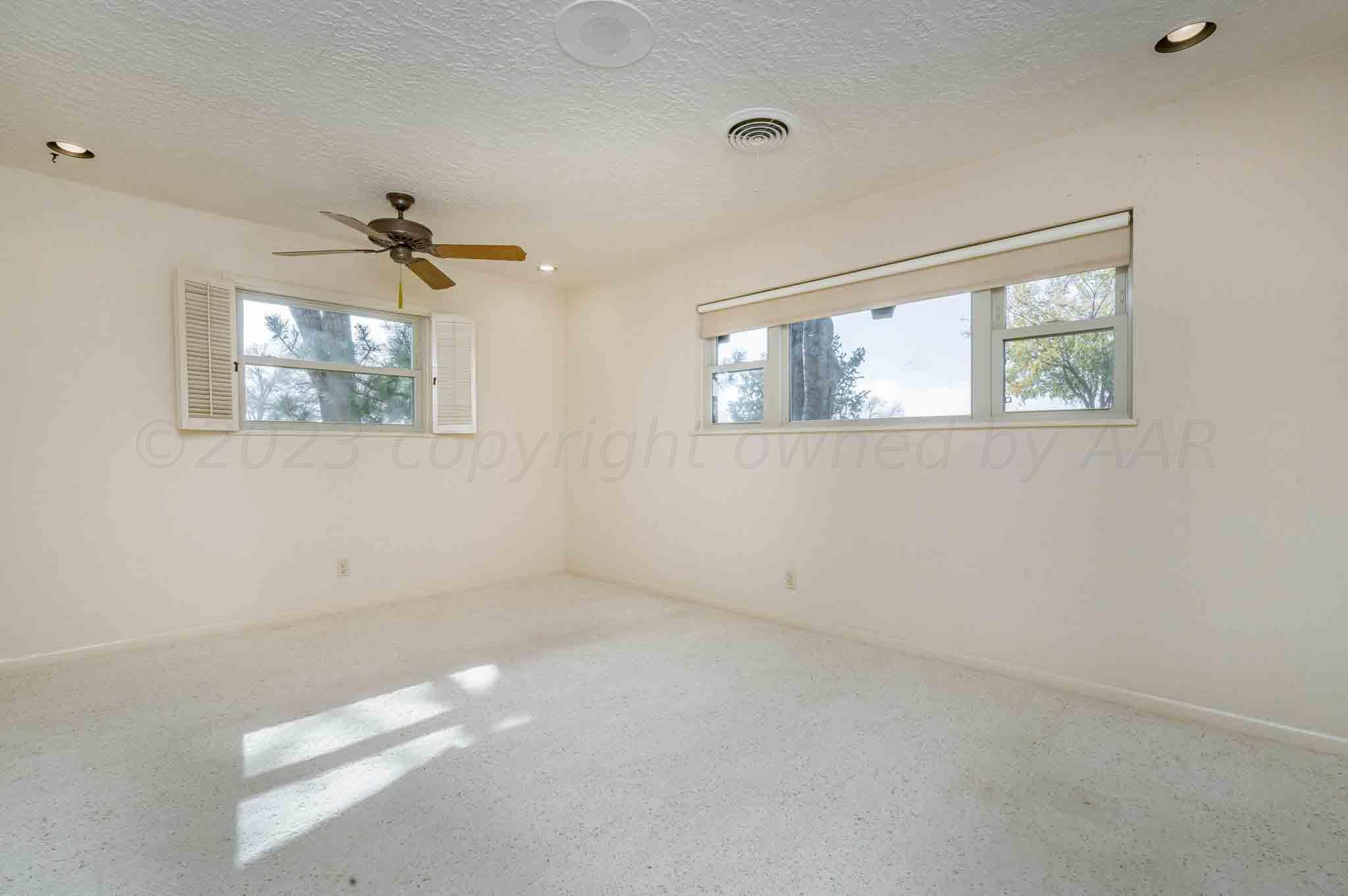 7517 Duling Lane Amarillo, TX 79110 - Photo 32 of 80 an empty room with windows and a ceiling fan