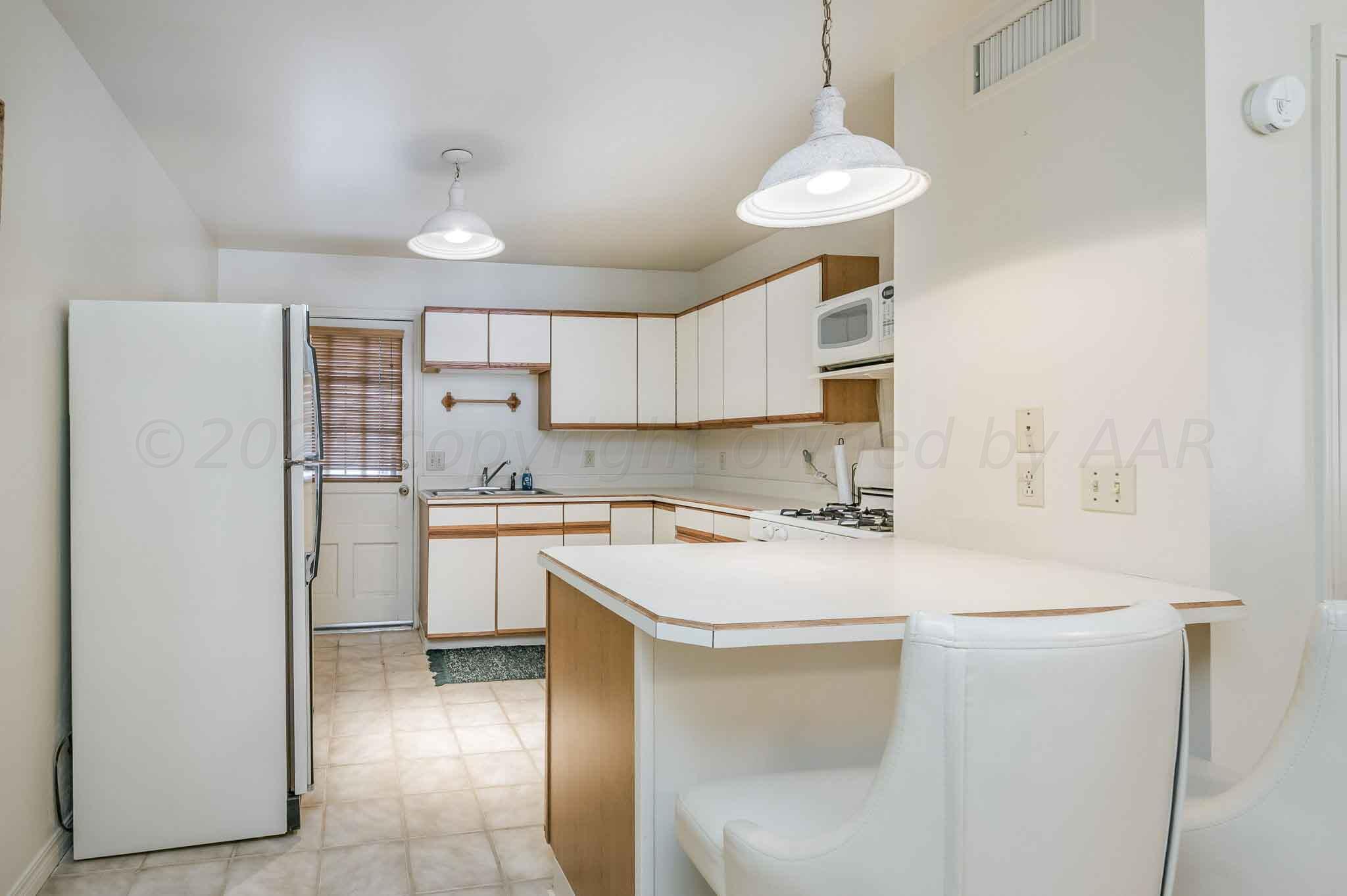 7517 Duling Lane Amarillo, TX 79110 - Photo 42 of 80 a kitchen with a sink a stove a refrigerator and cabinets