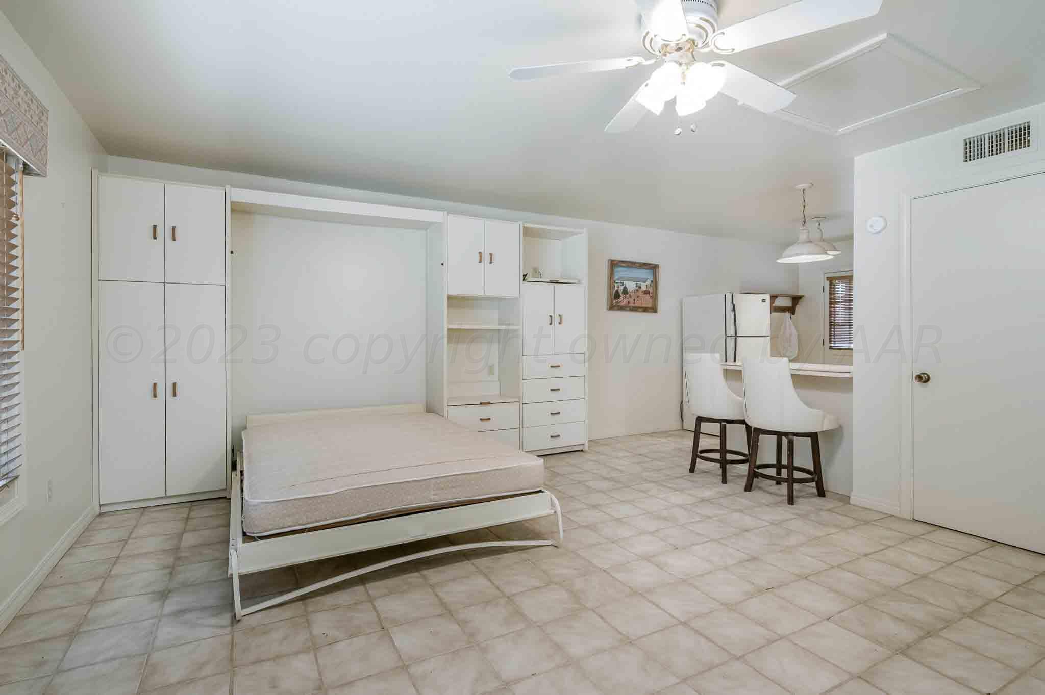 7517 Duling Lane Amarillo, TX 79110 - Photo 44 of 80 a spacious bedroom with a bed and a chandelier