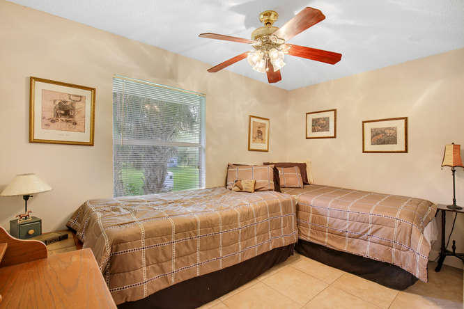 1032 Hyde Park Road Loxahatchee, FL 33470 - Photo 11 of 24 a bedroom with a bed and a chandelier
