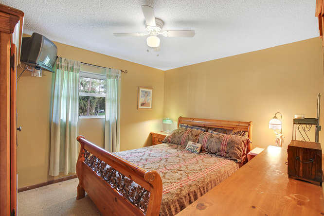 1032 Hyde Park Road Loxahatchee, FL 33470 - Photo 12 of 24 a bedroom with a bed dresser and a window