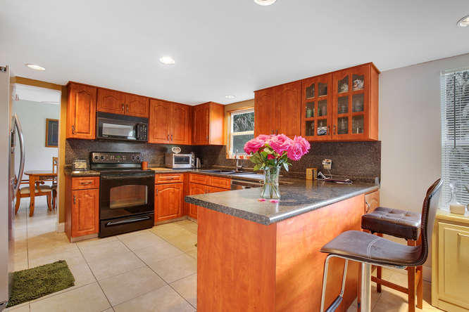 1032 Hyde Park Road Loxahatchee, FL 33470 - Photo 5 of 24 a kitchen with stainless steel appliances granite countertop a stove top oven a sink and dishwasher