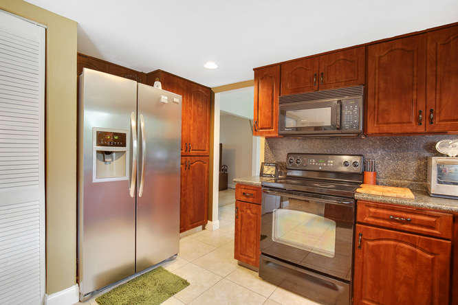 1032 Hyde Park Road Loxahatchee, FL 33470 - Photo 6 of 24 a kitchen with stainless steel appliances granite countertop a refrigerator and a stove top oven