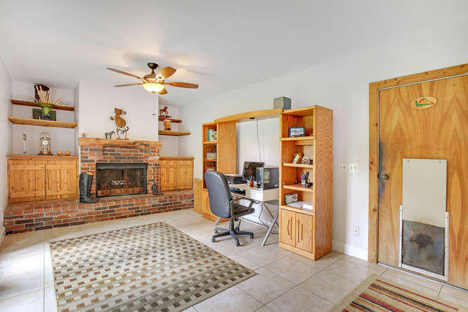 1032 Hyde Park Road Loxahatchee, FL 33470 - Photo 8 of 24 a living room with furniture a fireplace and a table with wooden floor