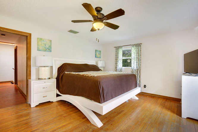 1032 Hyde Park Road Loxahatchee, FL 33470 - Photo 9 of 24 a bedroom with a bed and a flat screen tv