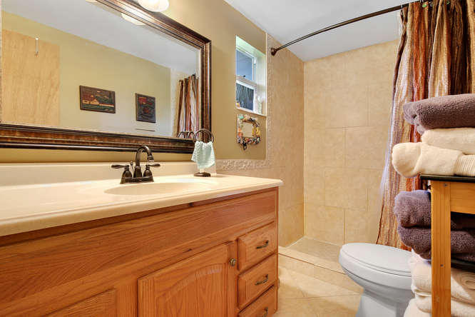 1032 Hyde Park Road Loxahatchee, FL 33470 - Photo 10 of 24 a bathroom with a sink a toilet a mirror and shower curtain