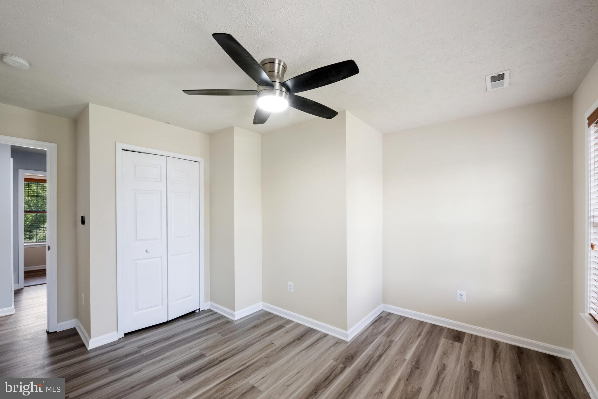 35184 Pheasant Ridge Road Locust Grove, VA 22508 - Photo 24 of 64 an empty room with wooden floor a ceiling fan and windows