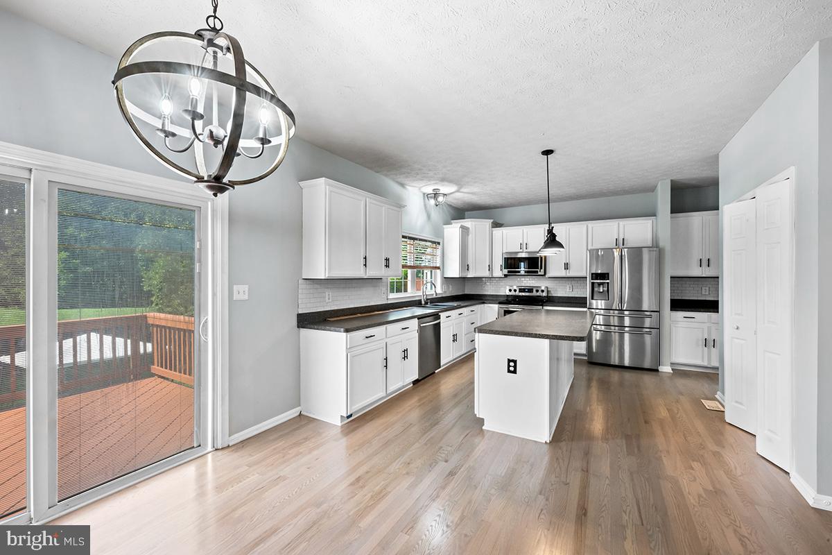 35184 Pheasant Ridge Road Locust Grove, VA 22508 - Photo 41 of 64 a kitchen with stainless steel appliances granite countertop a refrigerator a stove a sink and a wooden floors