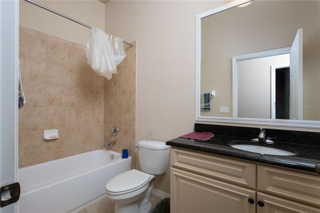 7775 Southwest 80th Drive Gainesville, FL 32608 - Photo 13 of 29 a bathroom with a granite countertop sink toilet and shower
