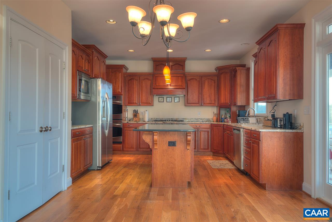 112 Creekside Court Ruckersville, VA 22968 - Photo 10 of 48 a kitchen with stainless steel appliances granite countertop a refrigerator a sink dishwasher a stove and a dining table with wooden floor