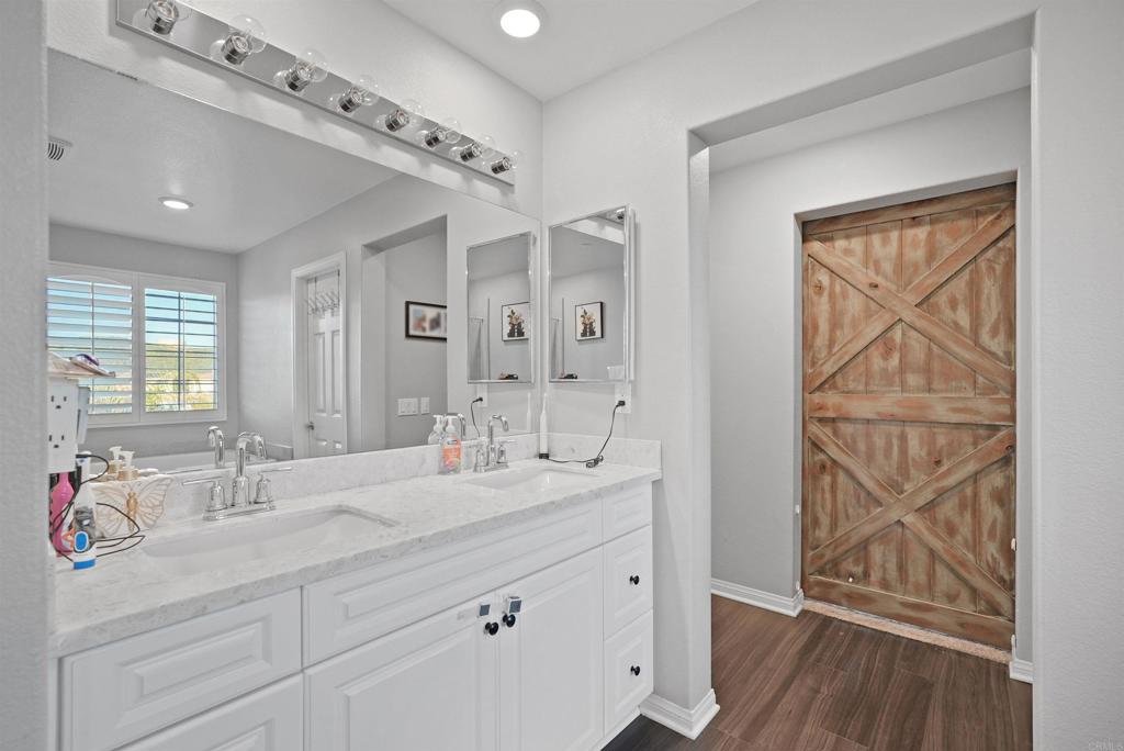 33009 Marin Fields Road Winchester, CA 92596 - Photo 30 of 51 a bathroom with a double vanity sink a mirror and a shower