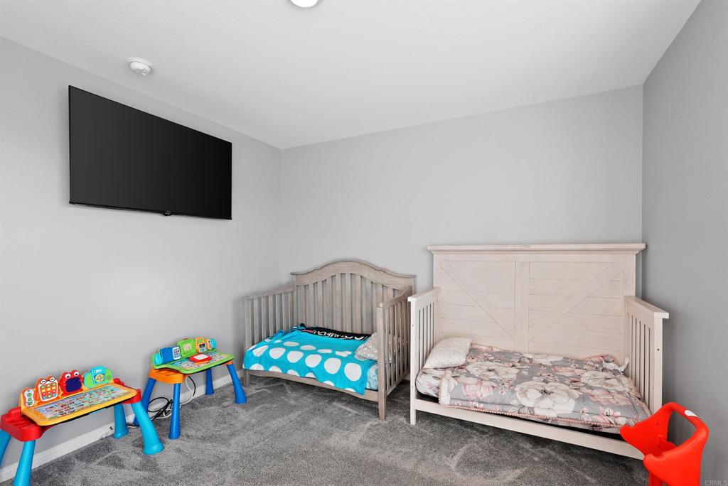 33009 Marin Fields Road Winchester, CA 92596 - Photo 35 of 51 a bedroom with furniture a baby crib and a couch