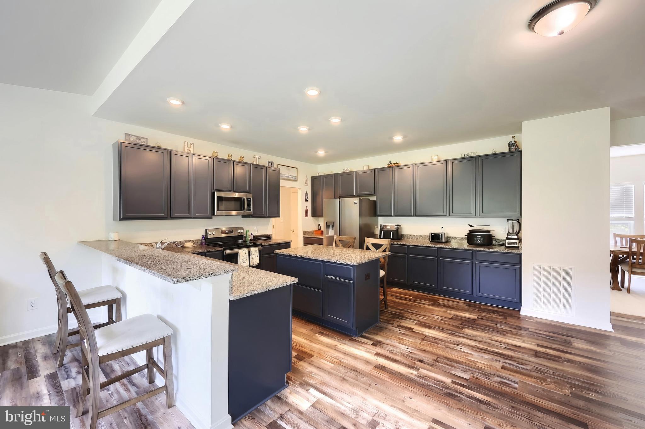 2741 Cold Springs Road Orrtanna, PA 17353 - Photo 21 of 52 a kitchen with stainless steel appliances kitchen island granite countertop a stove refrigerator and a sink