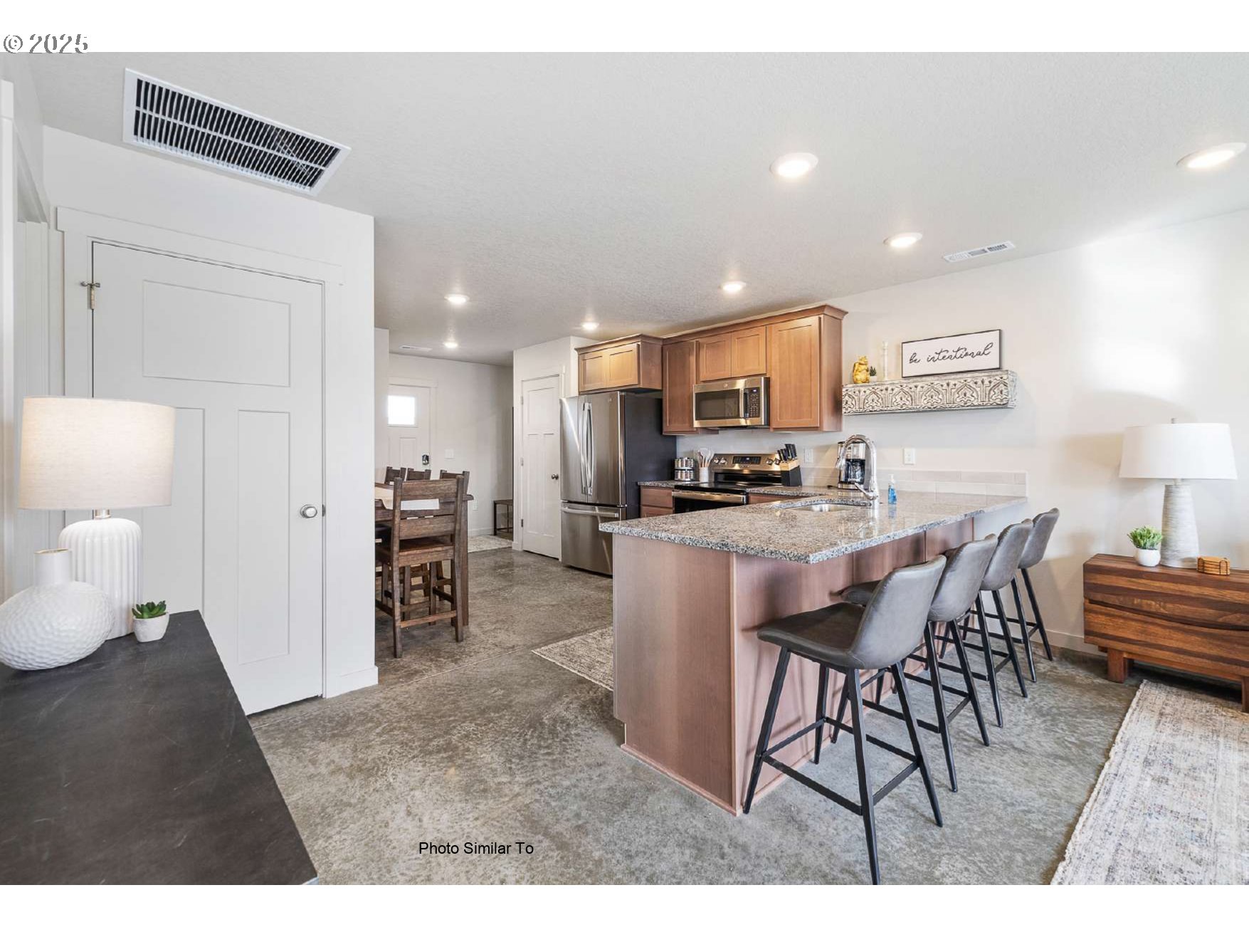 1184 Northeast 11th Street Hermiston, OR 97838 - Photo 20 of 23 a kitchen with stainless steel appliances kitchen island granite countertop a refrigerator a stove a sink a dining table and chairs with wooden floor