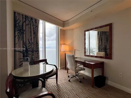 a view of a workspace with furniture and a window