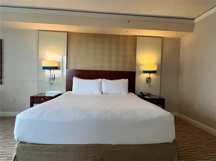 a large bed sitting in a bedroom next to a window