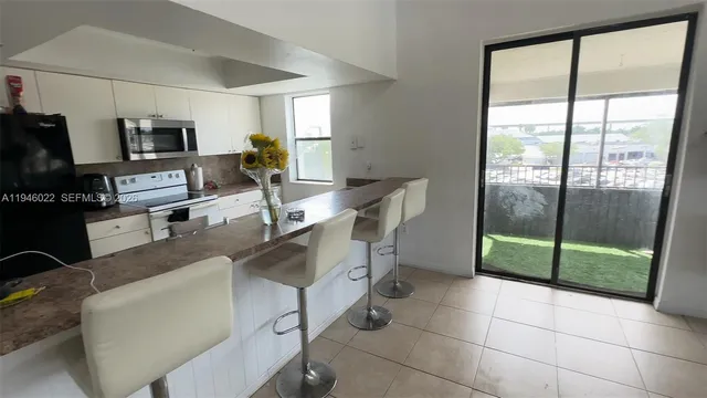 a work room with furniture a flat screen tv and a floor to ceiling window