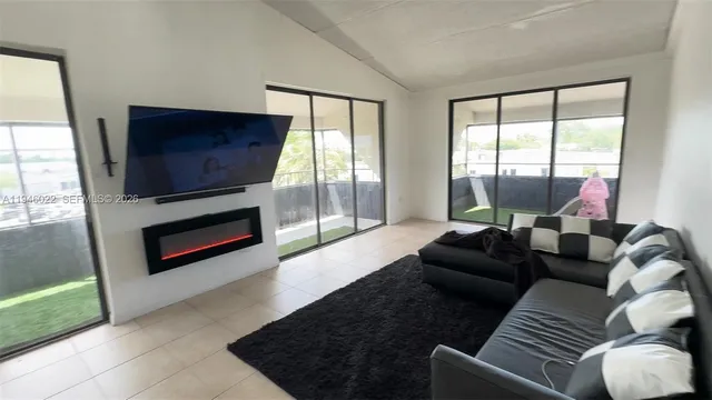 a living room with furniture a flat screen tv and a large window