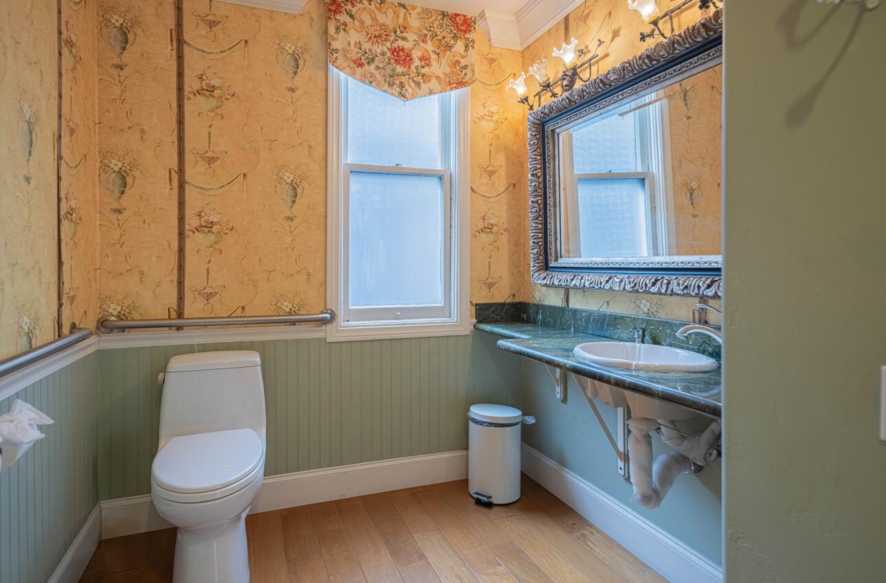157 15th Street Pacific Grove, CA 93950 - Photo 24 of 41 a bathroom with a granite countertop toilet a sink and a mirror