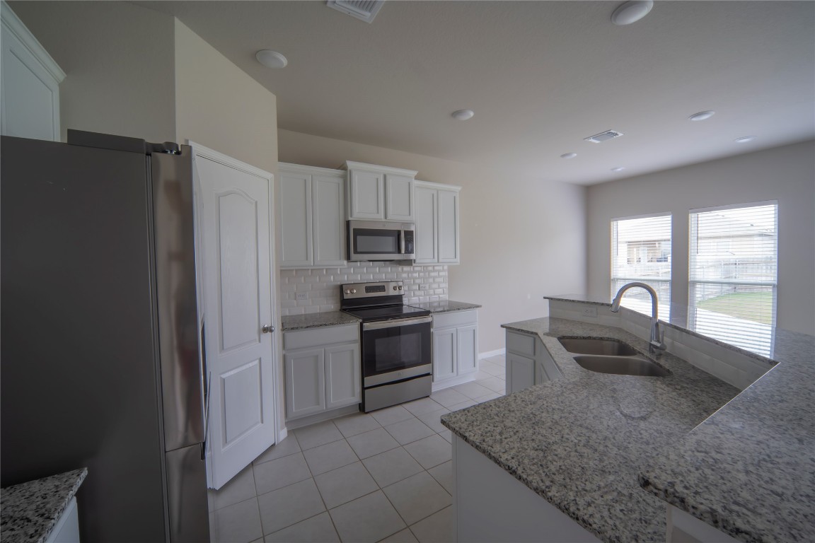 2208 Chia Court Temple, TX 76501 - Photo 4 of 16 a kitchen with granite countertop a refrigerator stove and sink