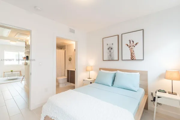 a bedroom with a bed and a painting on the wall