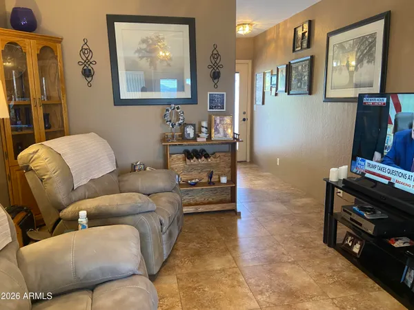 a living room with furniture a flat screen tv and a wall painting