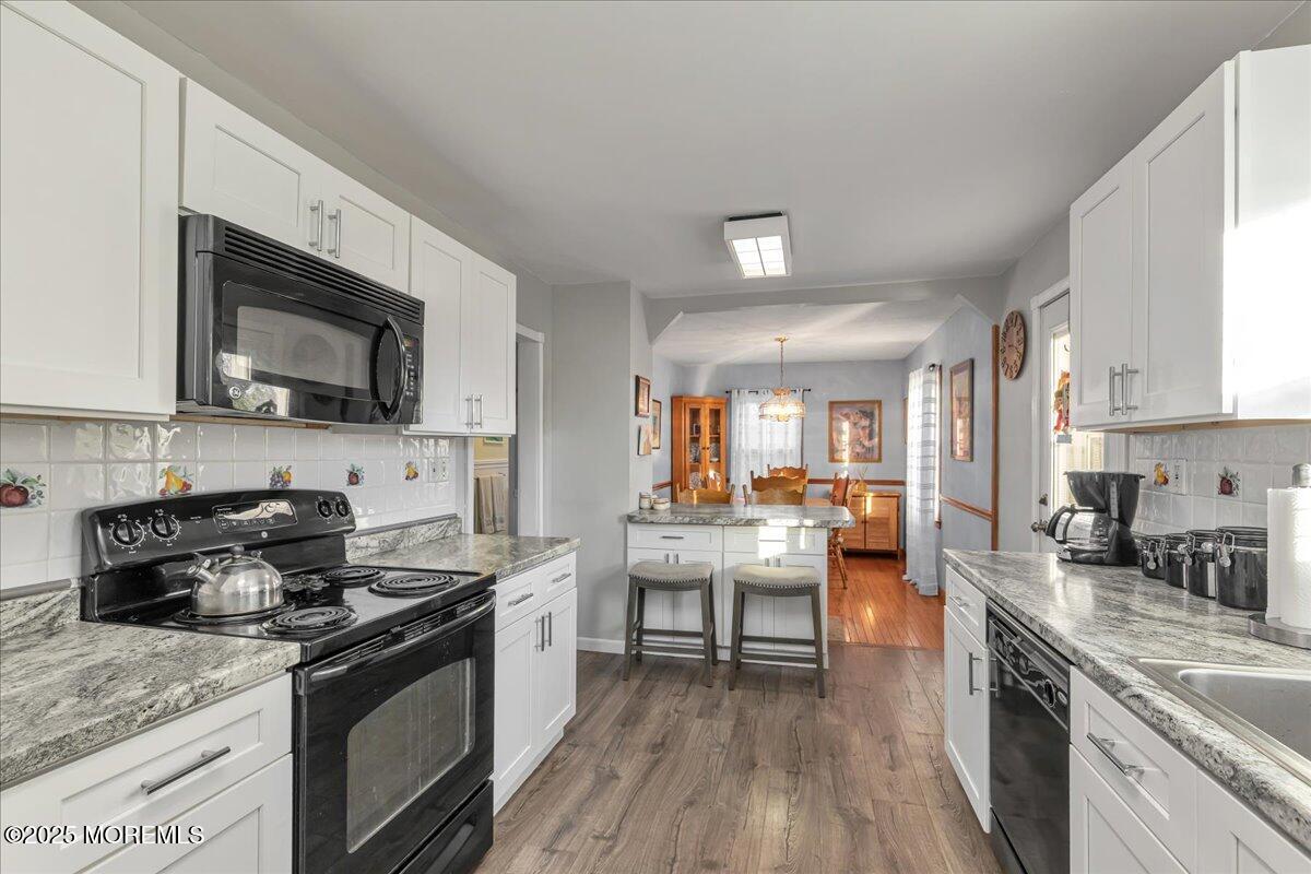 1211 18th Avenue West Belmar, NJ 07719 - Photo 12 of 40 a kitchen with stainless steel appliances granite countertop a stove top oven a sink dishwasher and white cabinets with wooden floor