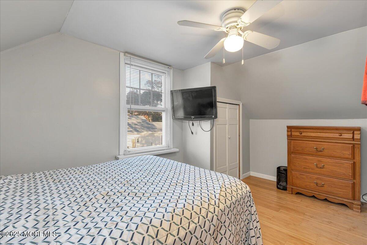 1211 18th Avenue West Belmar, NJ 07719 - Photo 22 of 40 a bedroom with a bed and a flat tv screen on dresser