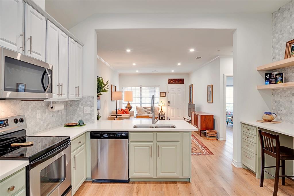 5713 Butterfly Way Fairview, TX 75069 - Photo 15 of 32 a kitchen with stainless steel appliances a sink a stove a refrigerator cabinets and wooden floor