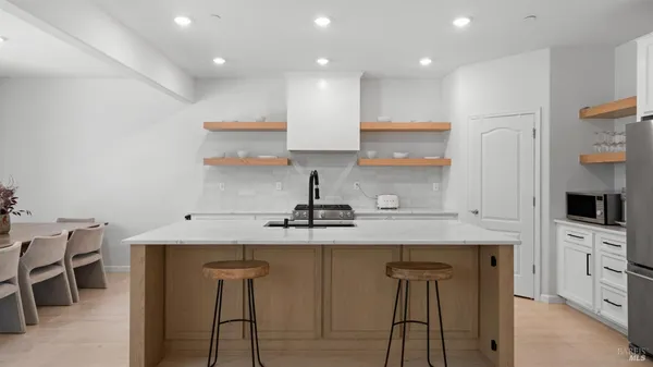 a kitchen with kitchen island granite countertop a sink a center island stainless steel appliances and cabinets