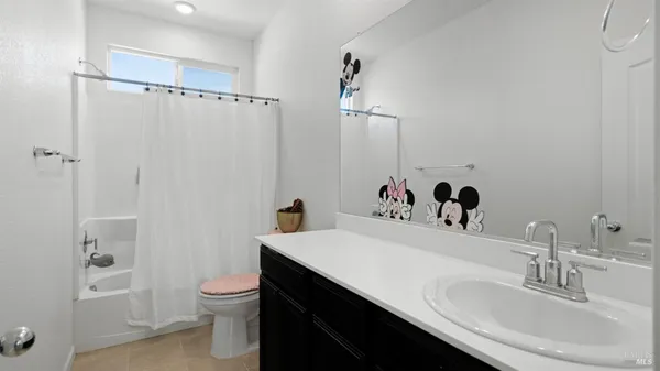 a bathroom with a sink toilet double vanity and tub