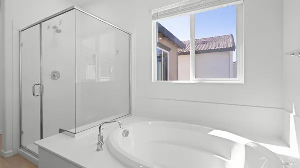 a bathroom with a white bath tub sitting next to shower