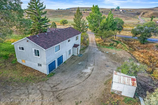 a view of a house with a yard and mountain view in back