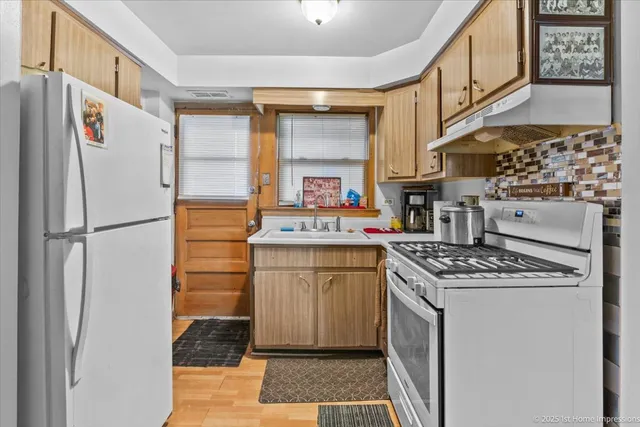 a kitchen with stainless steel appliances granite countertop a refrigerator stove and sink