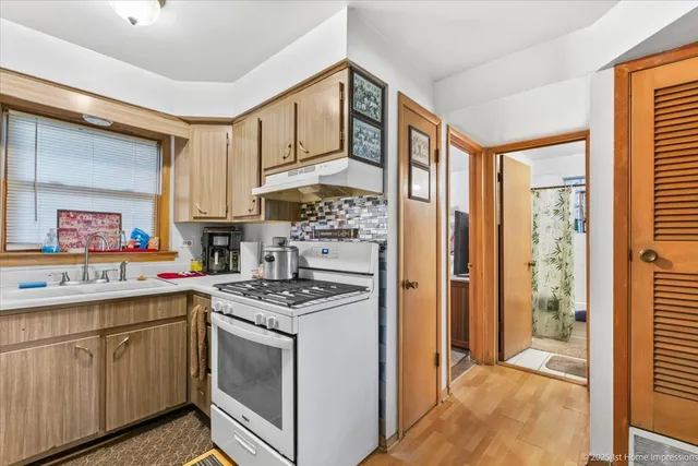 a kitchen with stainless steel appliances a stove a refrigerator and cabinets