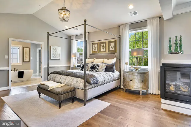 a bedroom with a bed couch and a fireplace