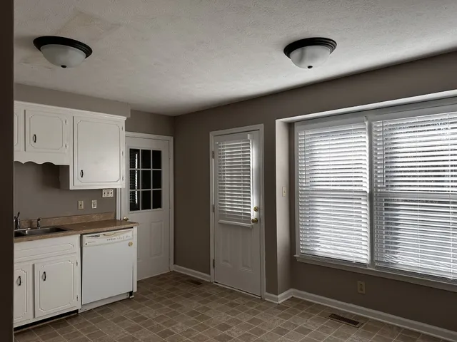 a kitchen with windows and cabinets