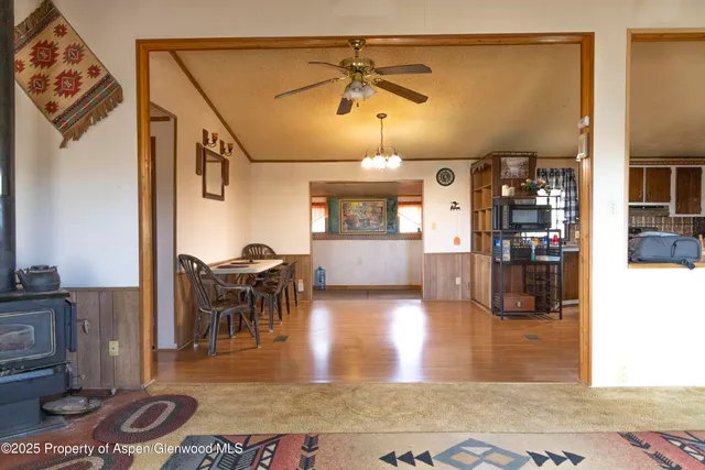 a view of a dining room and livingroom with furniture wooden floor a chandelier