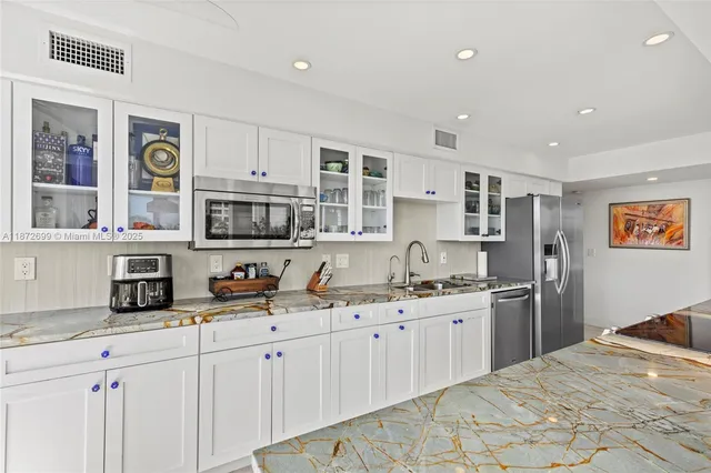 a kitchen with stainless steel appliances granite countertop a sink and cabinets