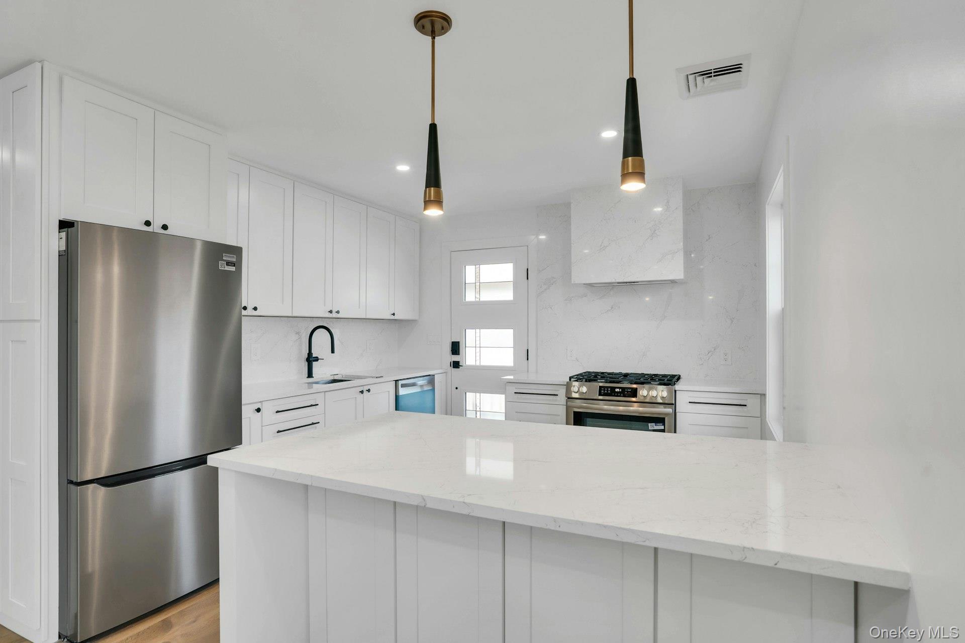 243 Lido Parkway Lindenhurst, NY 11757 - Photo 19 of 46 a kitchen with stainless steel appliances a refrigerator a stove a sink a center island and a cabinets