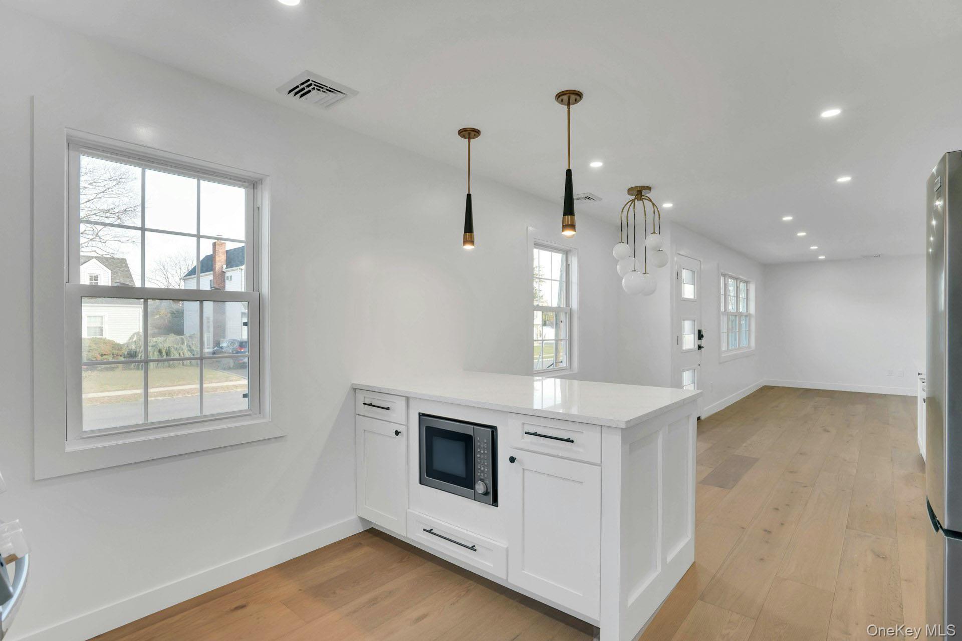 243 Lido Parkway Lindenhurst, NY 11757 - Photo 22 of 46 a view of a kitchen with a stove cabinets and a wooden floor