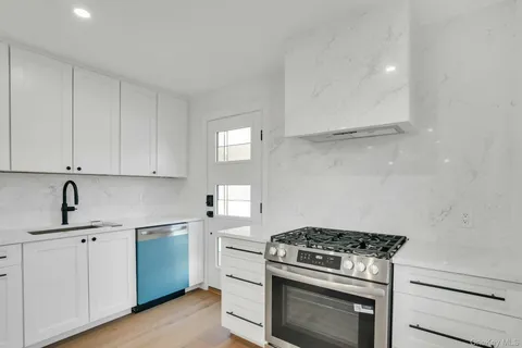 a kitchen with white cabinets and appliances