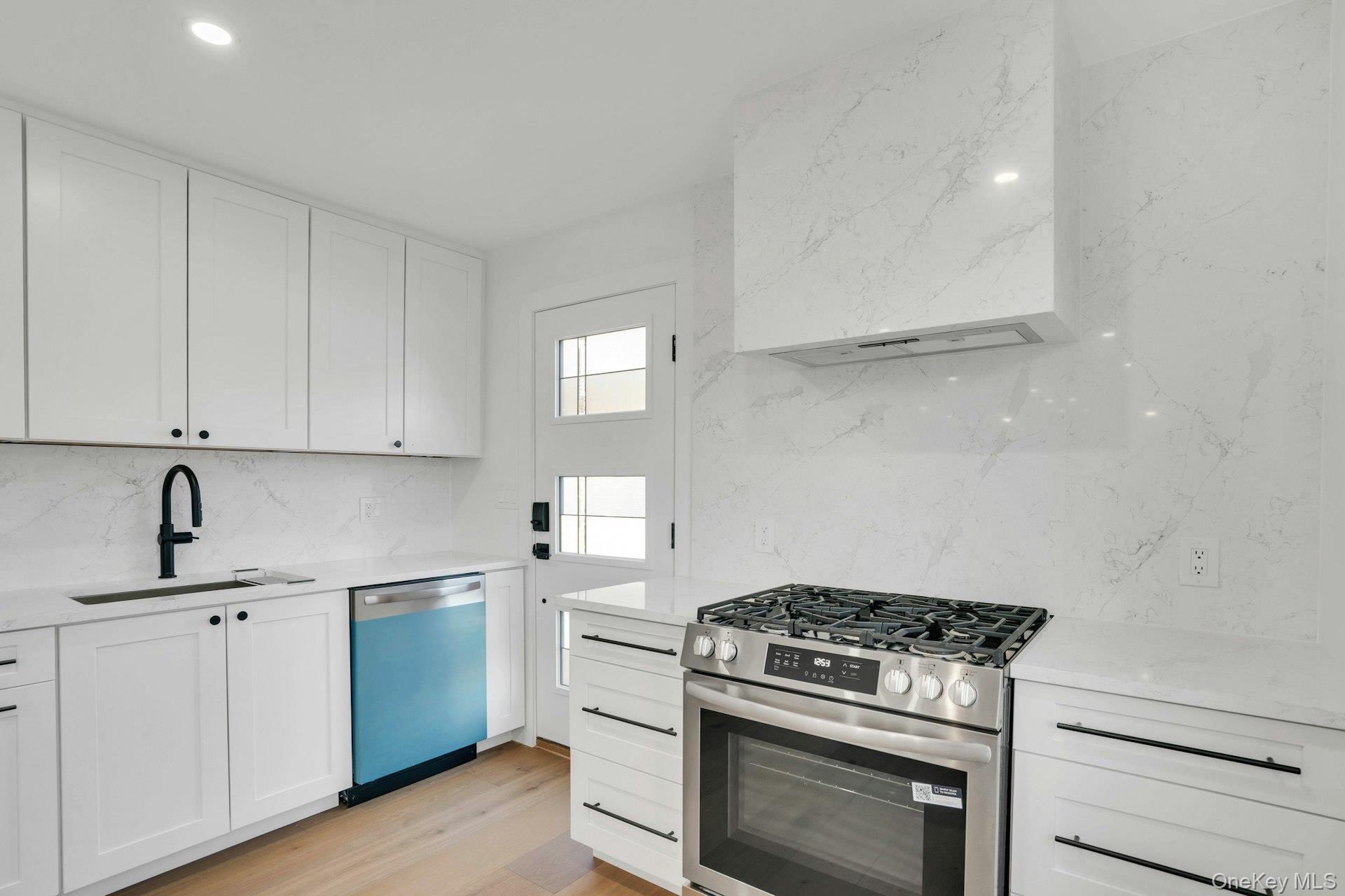 243 Lido Parkway Lindenhurst, NY 11757 - Photo 23 of 46 a kitchen with white cabinets and appliances