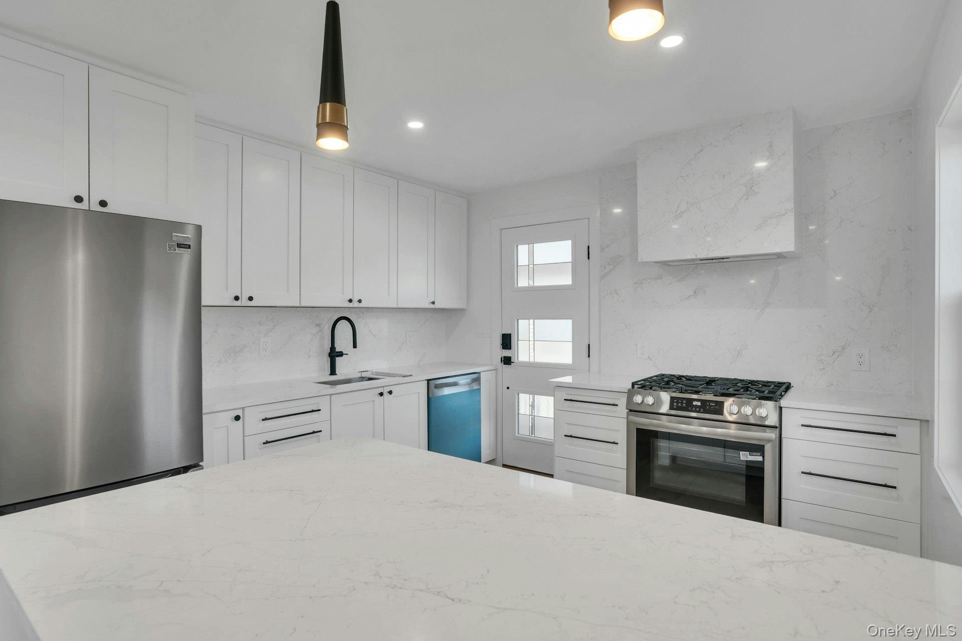 243 Lido Parkway Lindenhurst, NY 11757 - Photo 25 of 46 a kitchen with white cabinets and stainless steel appliances
