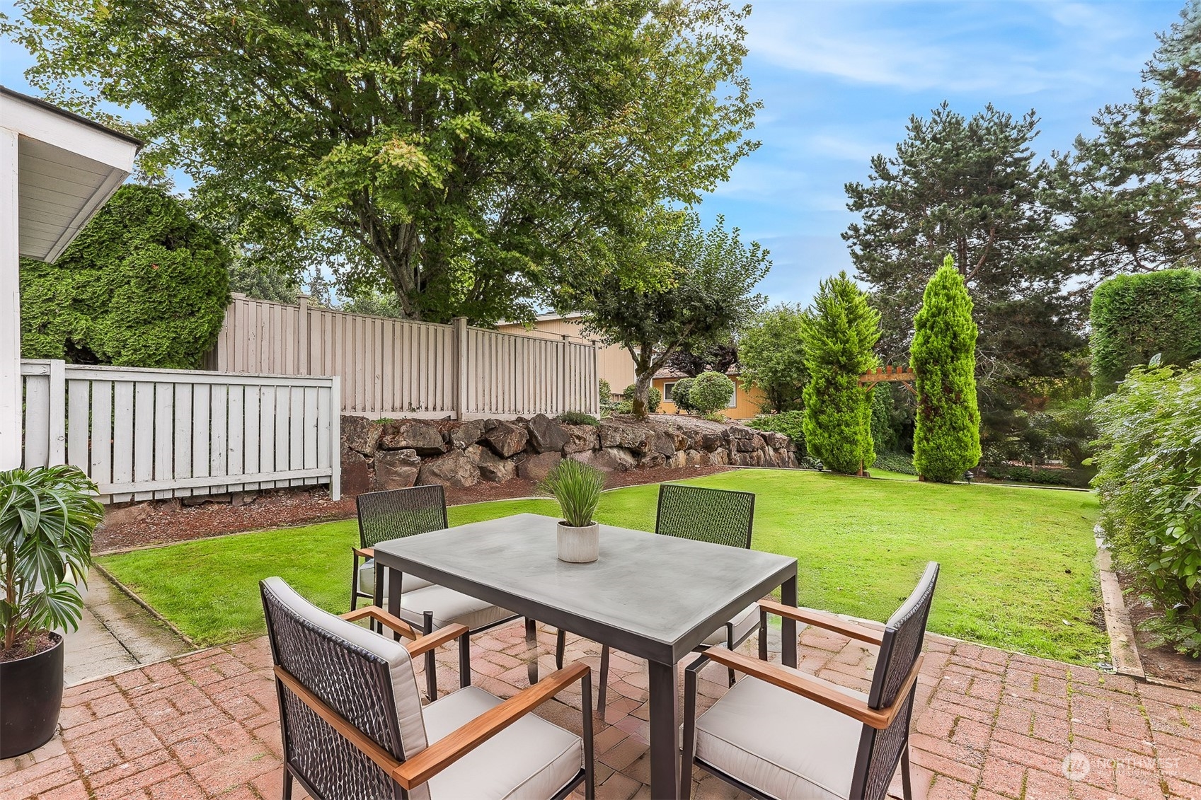 828 240th Place Southwest Bothell, WA 98021 - Photo 23 of 40 a view of a backyard with table and chairs potted plants and tree