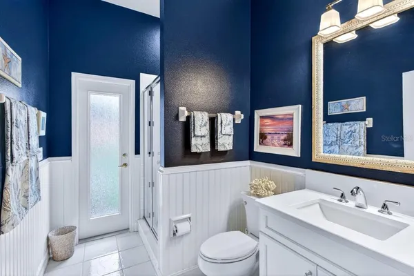 a bathroom with a toilet a sink a mirror a shower and vanity