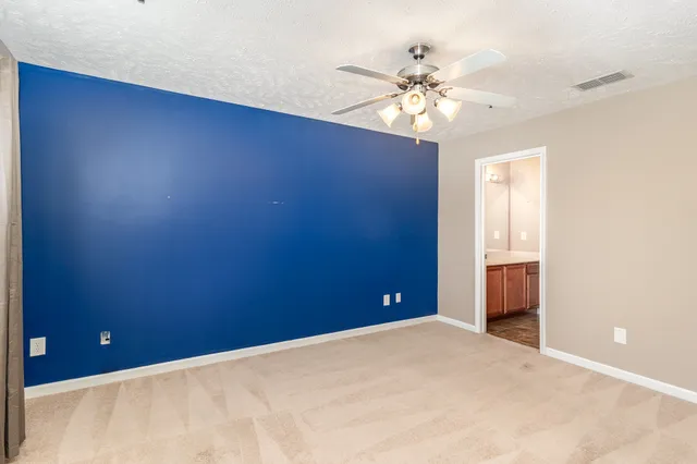 wooden floor in an empty room and a chandelier fan