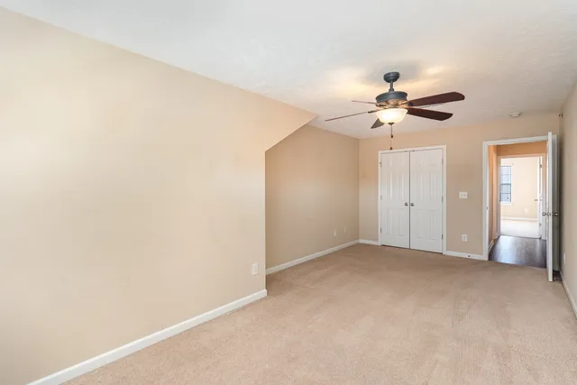 a view of an empty room with a ceiling fan